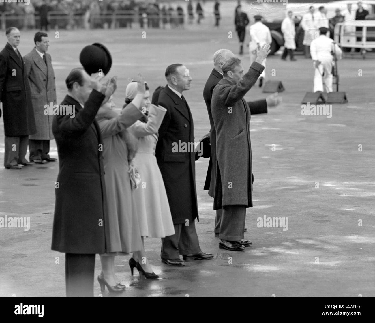 Visto por otros miembros de la familia real, la princesa Elizabeth y el duque de Edimburgo abandonaron el aeropuerto de Londres hacia Nairobi, Kenia, al comienzo de su excursión. El rey Jorge VI (r), la reina (más tarde la madre reina) y la princesa Margarita ondean del asfalto cuando el avión despida. El Rey murió el 6th de febrero de 1952. Foto de stock