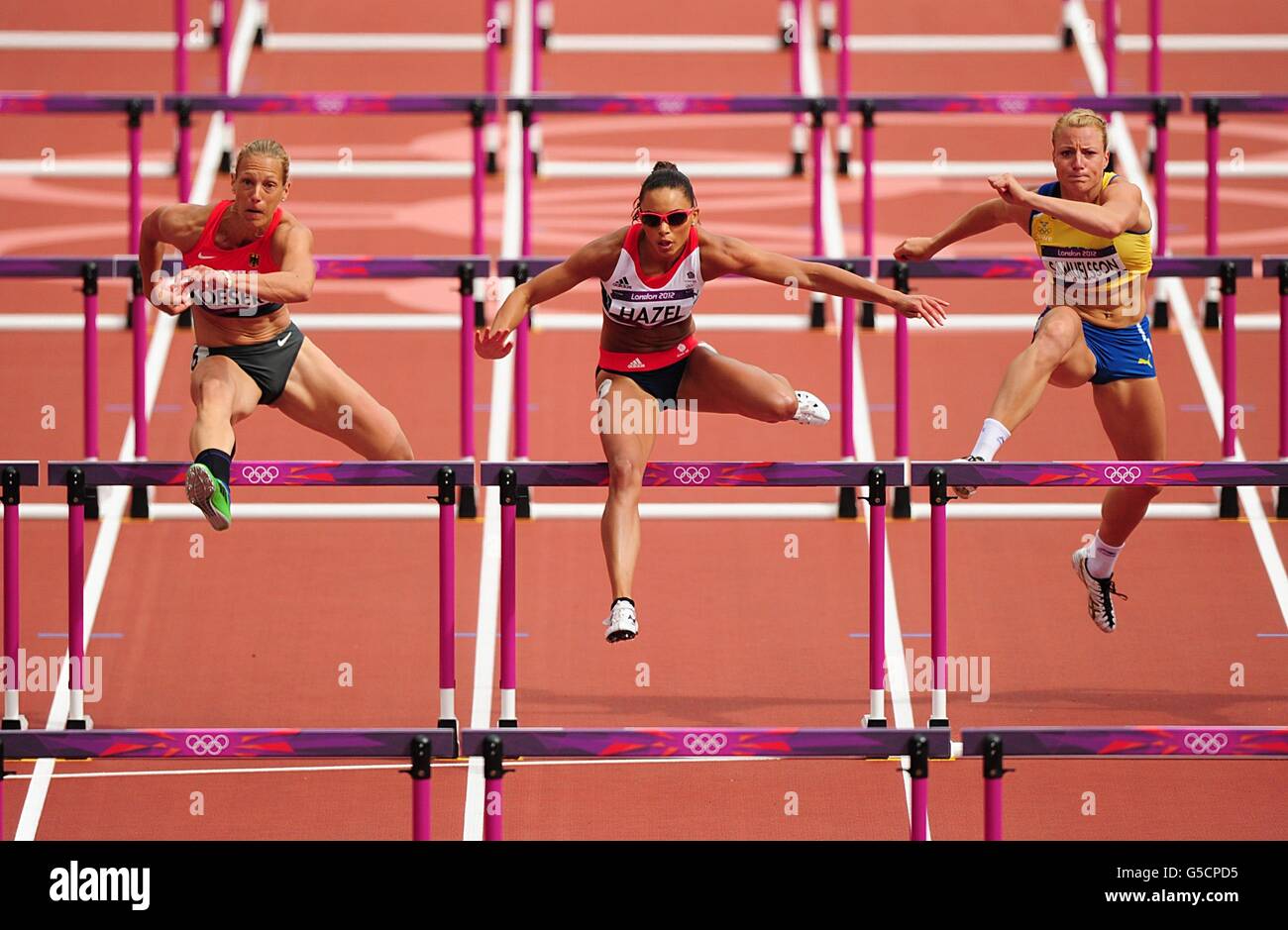 Louise Hazel (centro) de Gran Bretaña, Jessica Samuelsson (derecha) de Suecia y Jennifer Oeser de Alemania (izquierda) durante el calor 5 de los 100m obstáculos Heptathlon de las mujeres en el Estadio Olímpico de Londres. Foto de stock