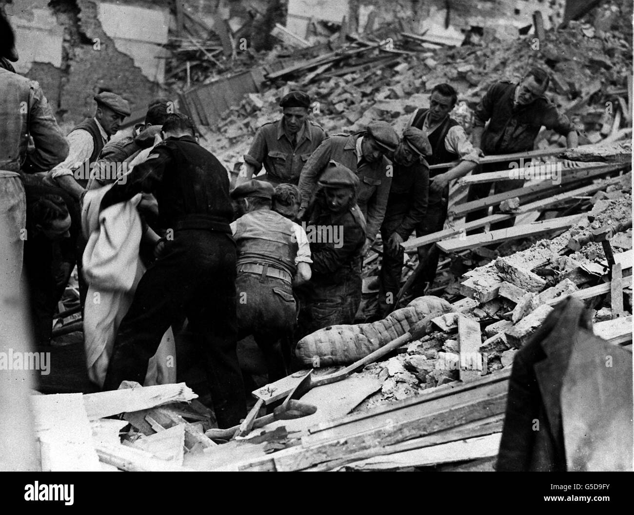 El AIRE ALEMÁN RAID 1943: Después de horas de trabajo duro un hombre es liberado de debajo de una gran pila de escombros después de una incursión nocturna por la Luftwaffe en el área de Londres. Foto de la colección de la Segunda Guerra Mundial de PA. Foto de stock
