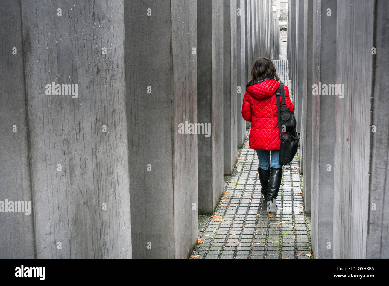Una mujer en una chaqueta roja en el Memorial a los judíos asesinados de Europa o el Memorial del Holocausto, Berlín, Alemania Foto de stock