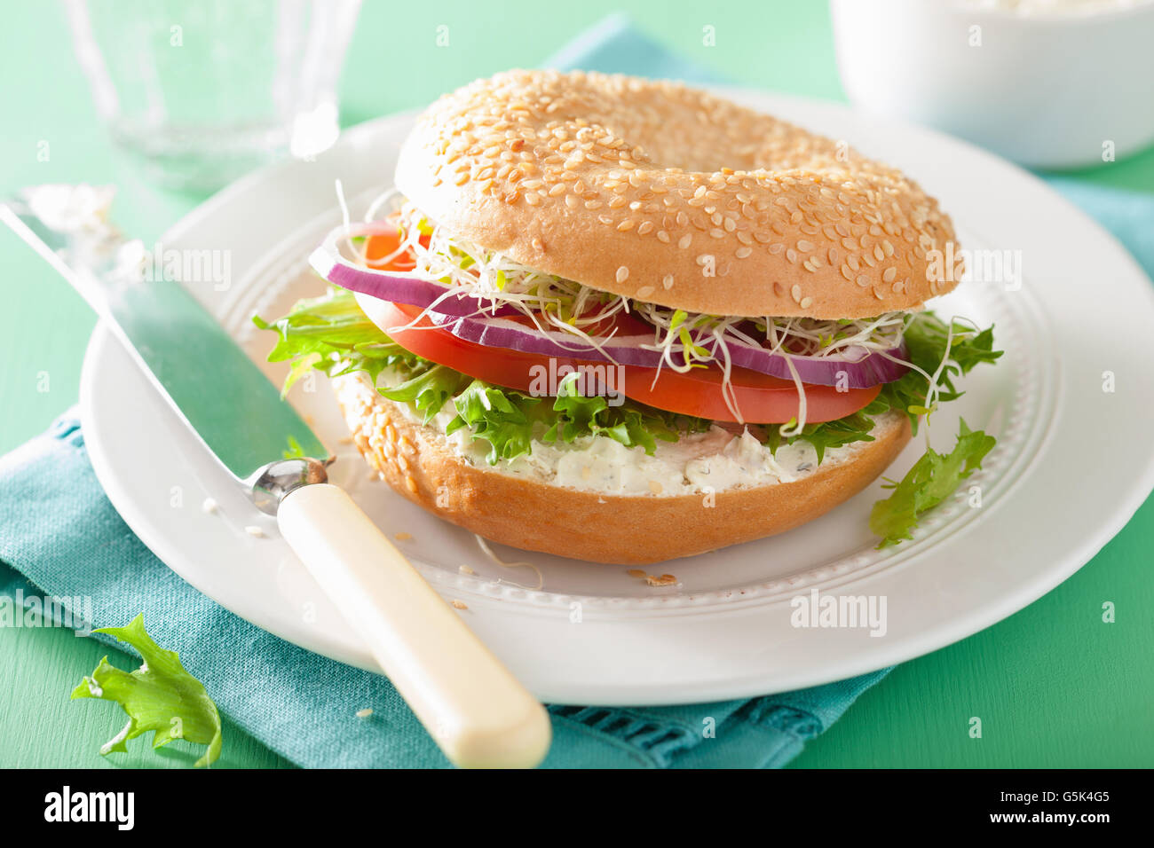 Sándwich de tomate en bagel con queso crema de lechuga cebolla brotes de alfalfa Foto de stock