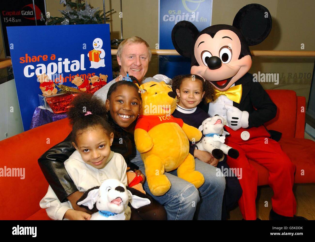 Chris Tarrant, presentador de radio de FM capital con Mickey Mouse y niños  de izquierda a derecha; Shereen Campbell, 6, T'Shai Raymond, 6 y Sophie  Campbell, 7, en el lanzamiento de 'Share