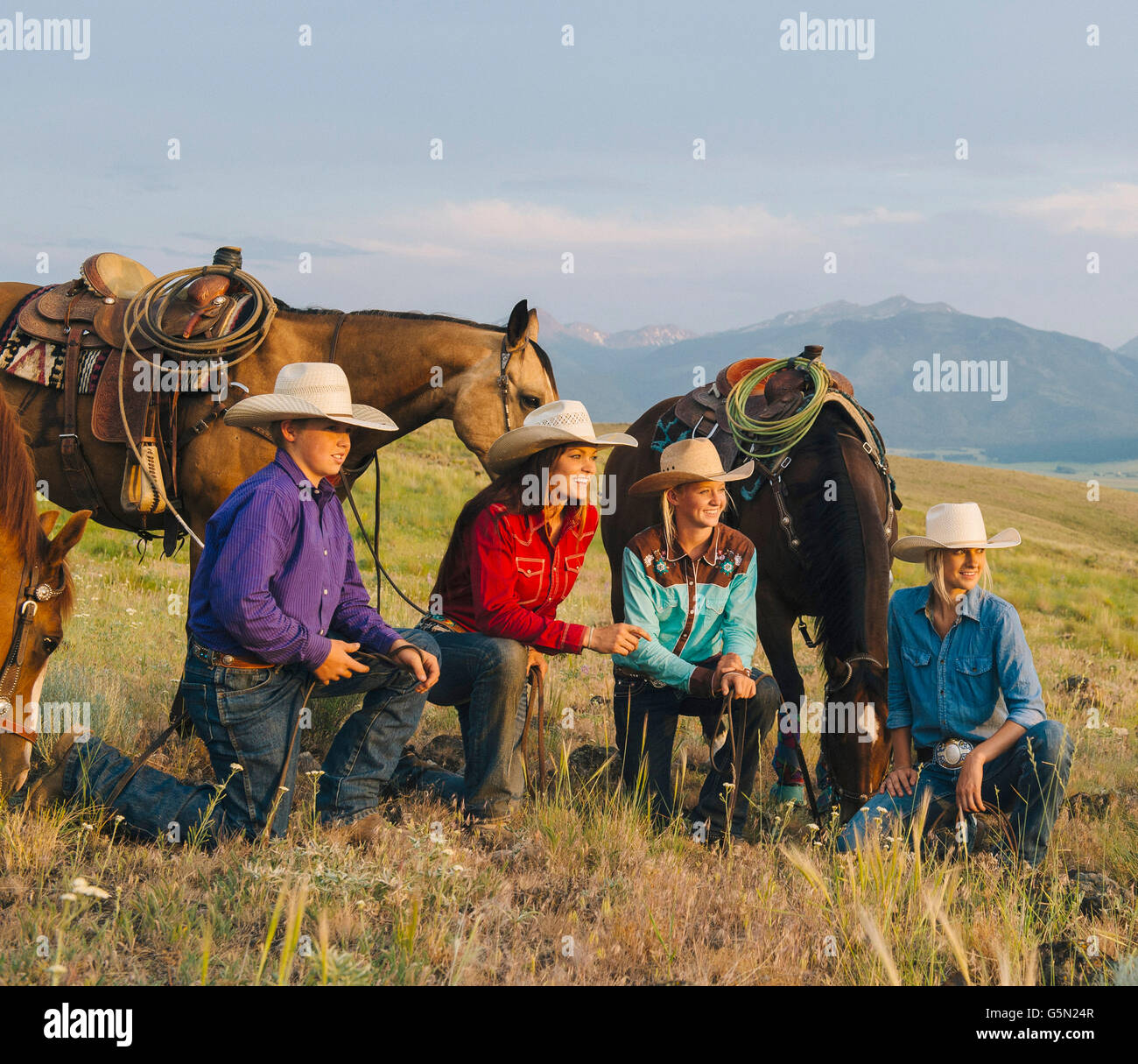 Vaqueros y vaqueras con caballos en el rancho Foto de stock