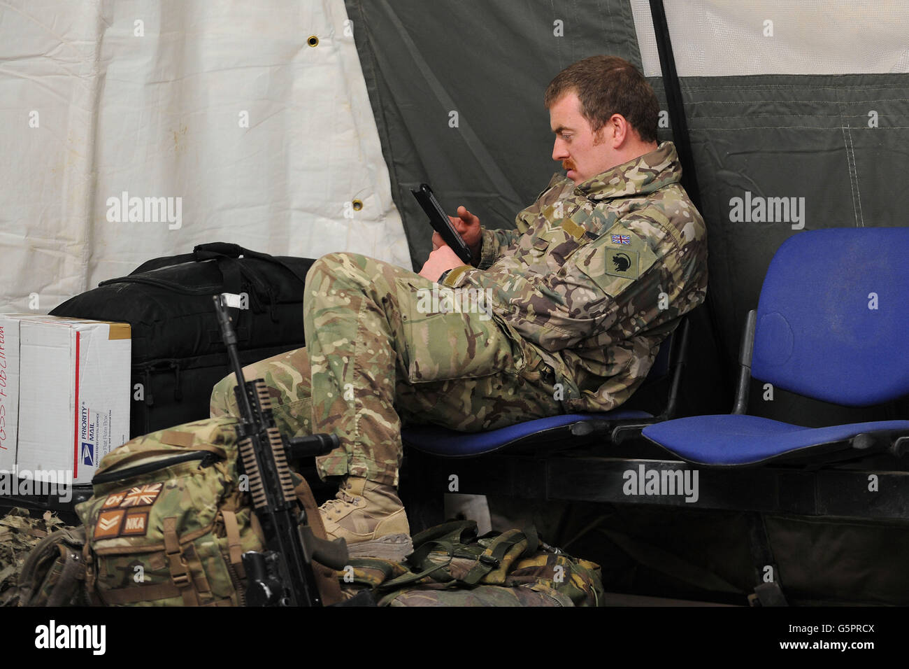 Tropas en Afganistán. Un soldado sin nombre esperando un vuelo en helicóptero desde Camp Bastion, Afganistán. Foto de stock