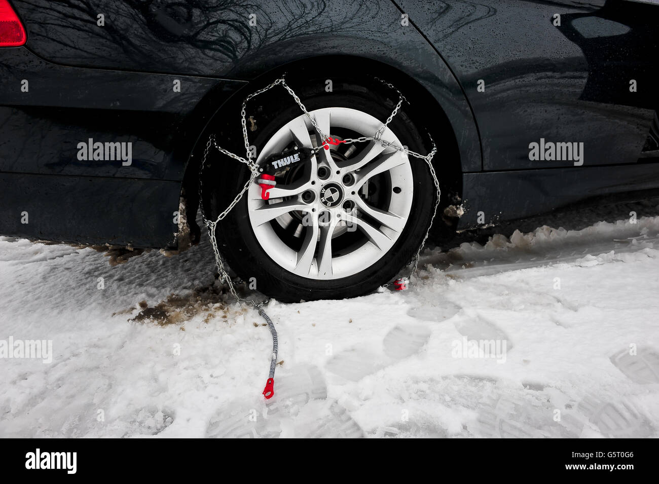 THULE CG-9 Snow-Chains, en la rueda trasera, pero el auto-tensor aún está conectado, a un vehículo BMW tracción trasera. Las cadenas para nieve ayudan a conducir a través la nieve,