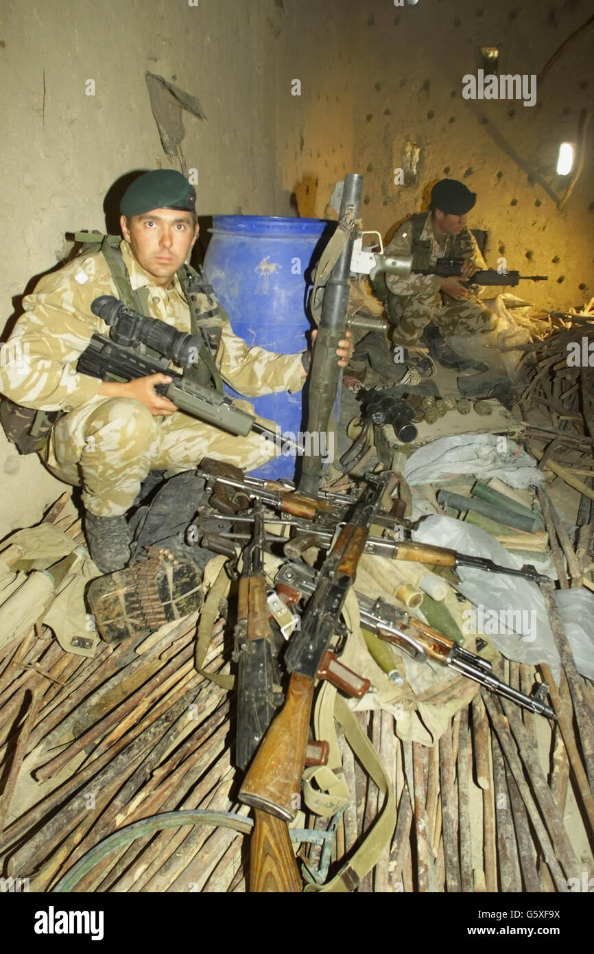 Los militares británicos, el segundo teniente David Spink (izquierda) y el cabo John Andrews examinan las armas encontradas en un granero de barro en la aldea de Atalay, a 50 millas al noroeste de Kandahar, en el sur de Afganistán. *... donde los Royal Marines y las fuerzas especiales de EE.UU. Han descubierto un depósito de armas y explosivos durante una incursión. Las tropas encontraron armas, explosivos plásticos y equipo de fabricación de bombas, así como documentos de valor de inteligencia que se están analizando. Los soldados creen que una persona que duerme en el granero huye momentos antes de que las tropas llegaran en helicóptero, ya que encontraron una lámpara de aceite todavía ardiendo y Foto de stock