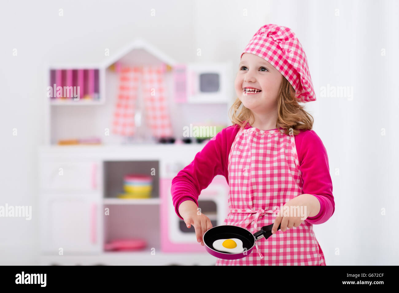 Niña y Niño en chef hat delantal y cocinar en una cocina de juguete.  Juguetes educativos para niños Fotografía de stock - Alamy