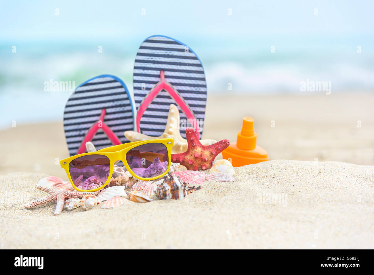 Flip-flops y conchas en la playa. Todavía la vida de verano. Foto de stock
