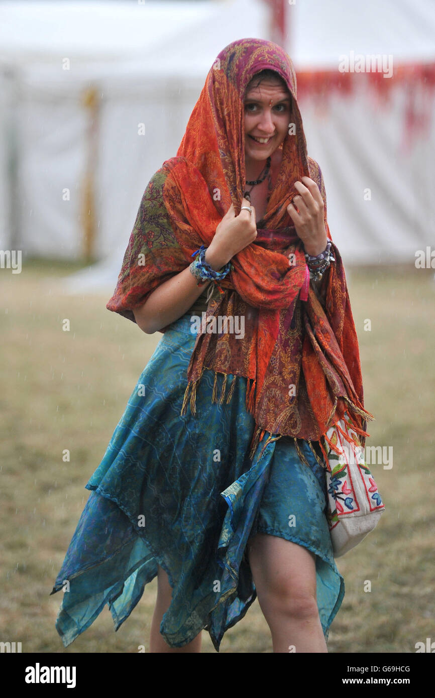 Un goer del festival corre a refugiarse de la lluvia durante el Festival de la Mujer 2013, celebrado en Charlton Park, Wiltshire. Foto de stock