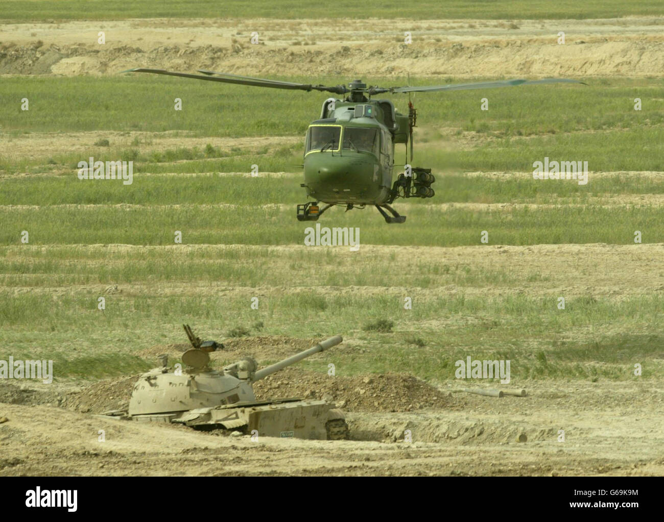 Un helicóptero Mark 7 Lynx del cuerpo aéreo del Ejército de 3 Reg, 16 Brigada de Asalto aéreo en una patrulla de combate, llevando misiles DE REMOLQUE, vuela sobre un tanque iraquí destruido T55, al sur de al Qurnah. Foto de stock
