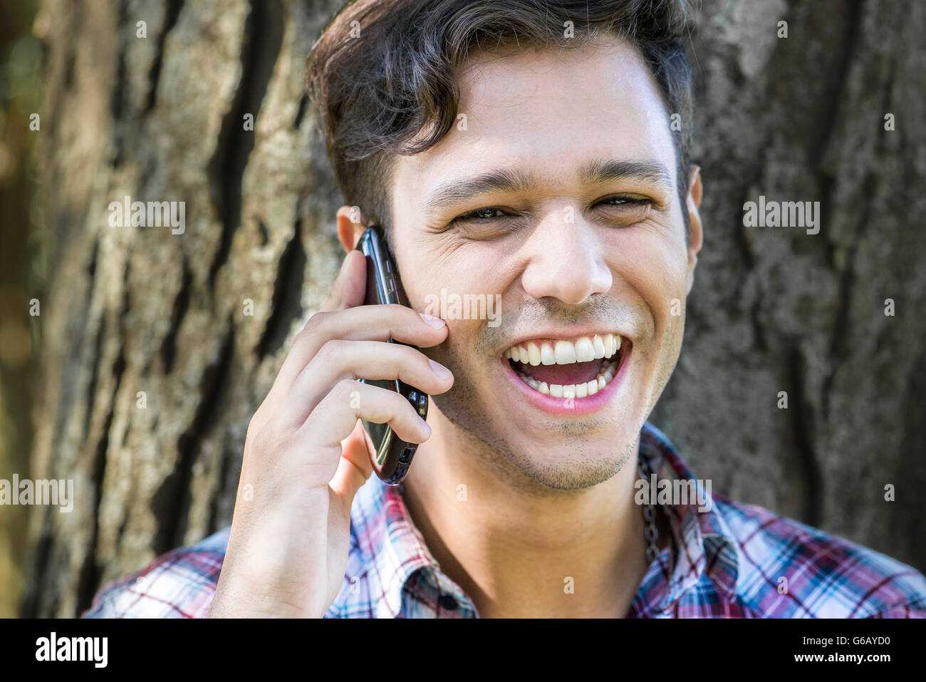 Hombre teniendo alegre conversación en teléfono celular Foto de stock