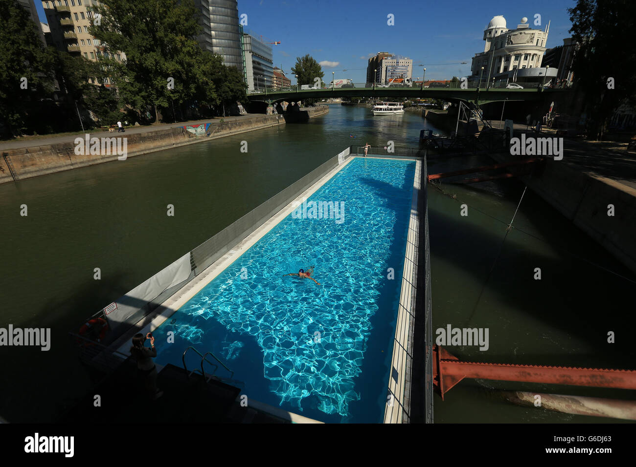 Un nadador se sumerge a bordo de una piscina flotante en el Donaukanal, Viena, Austria Foto de stock