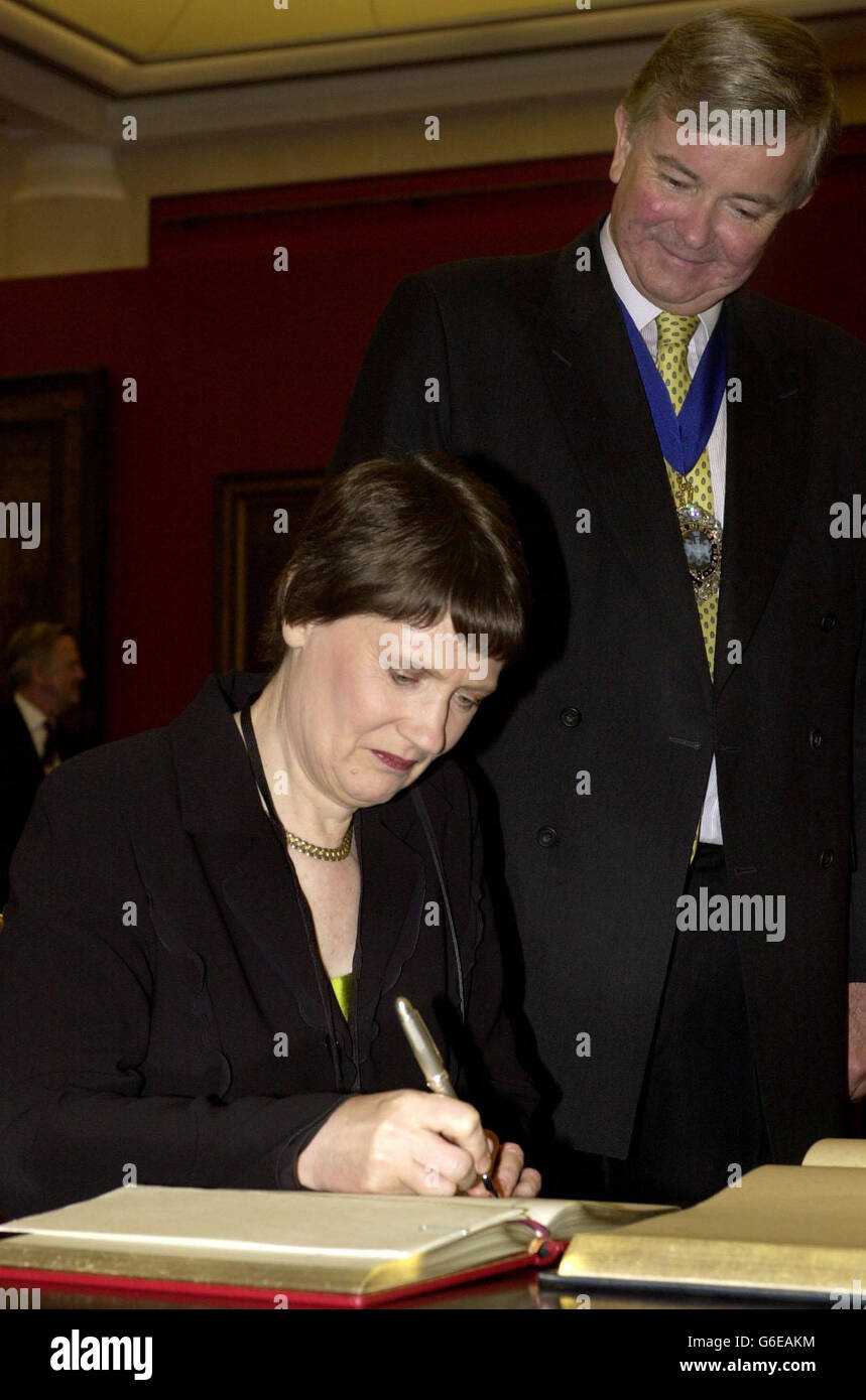 Gavyn Arthur, Lord Mayor de la Ciudad de Londres, a la derecha, mira como Helen Clark el Primer Ministro de Nueva Zelanda firma el libro de huéspedes , en el Guildhall en la Ciudad de Londres, para la cena progresiva de Gobernanza. Foto de stock