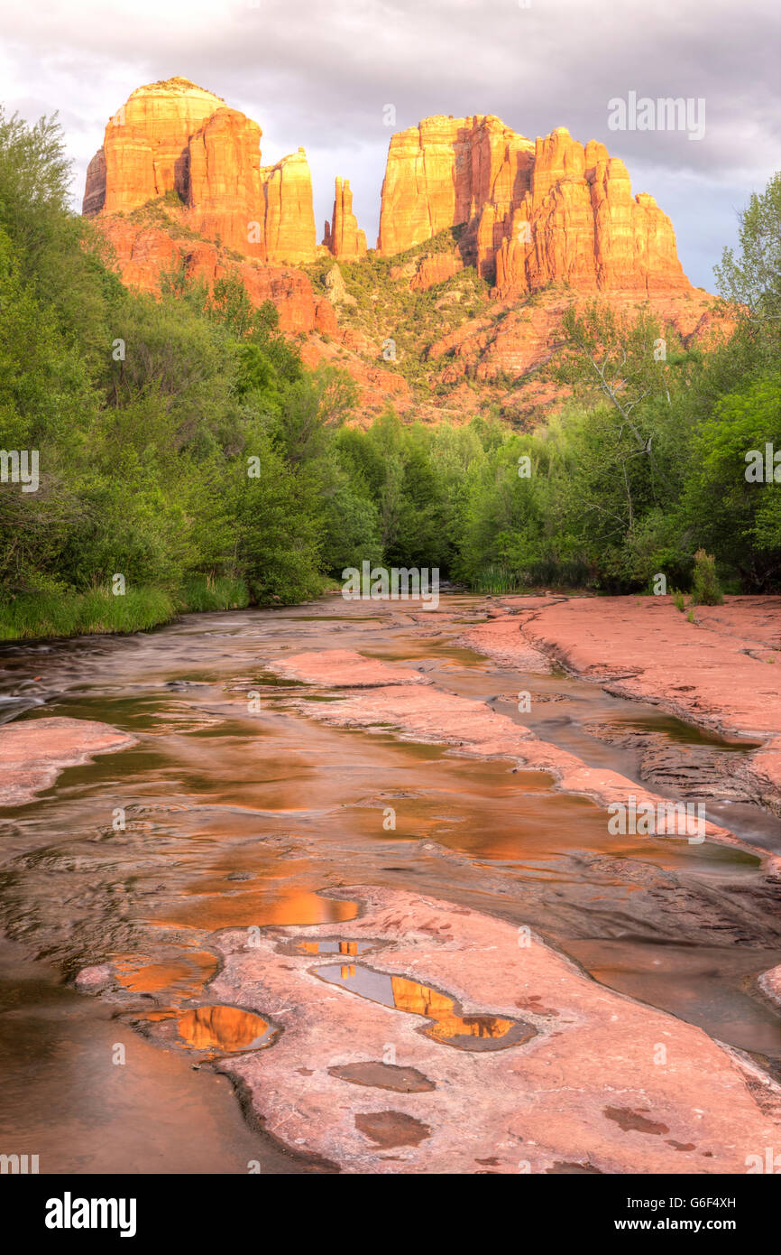 Cathedral Rock se refleja en los charcos en el slickrock en Oak Creek, en el Red Rock Cross-Crescent Luna Park en Sedona, Arizona Foto de stock