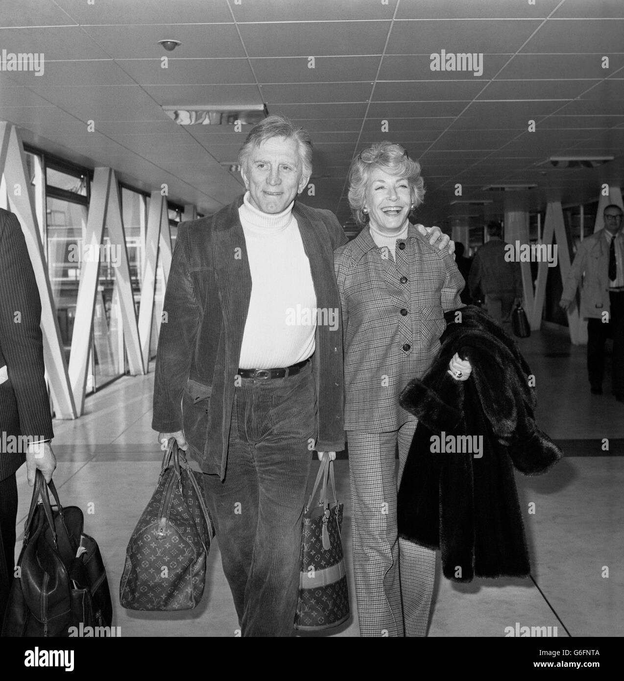 El actor de Hollywood Kirk Douglas, de 60 años, con su esposa Anne en el Aeropuerto Heathrow de Londres, donde volaban de regreso a Nueva York. Foto de stock