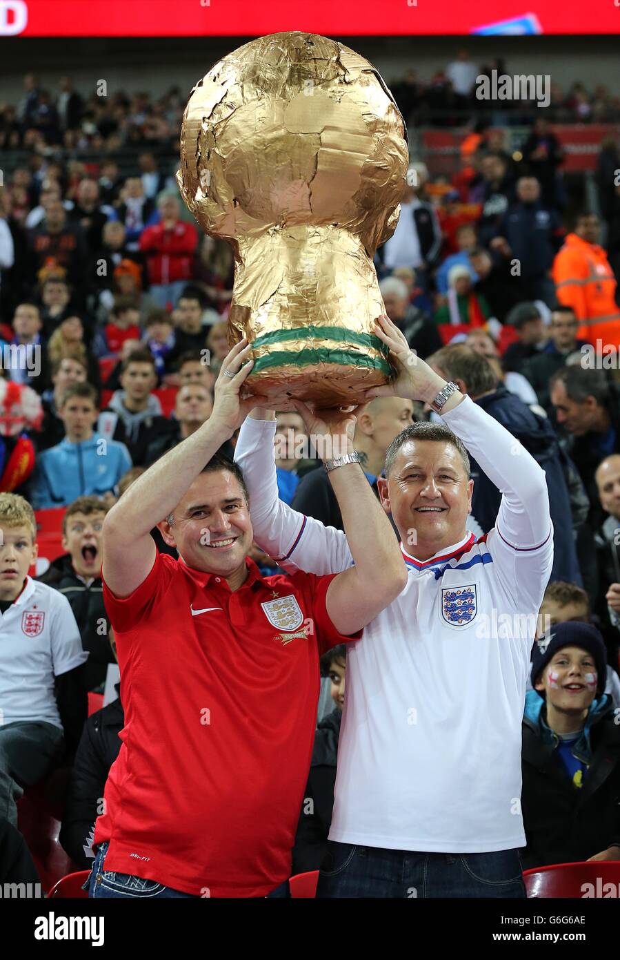 Fútbol - Copa Mundial de la FIFA - Grupo H - Inglaterra contra Montenegro - Estadio Wembley. Los fans de Inglaterra sostienen un trofeo casero de la copa del mundo en los stands Foto de stock