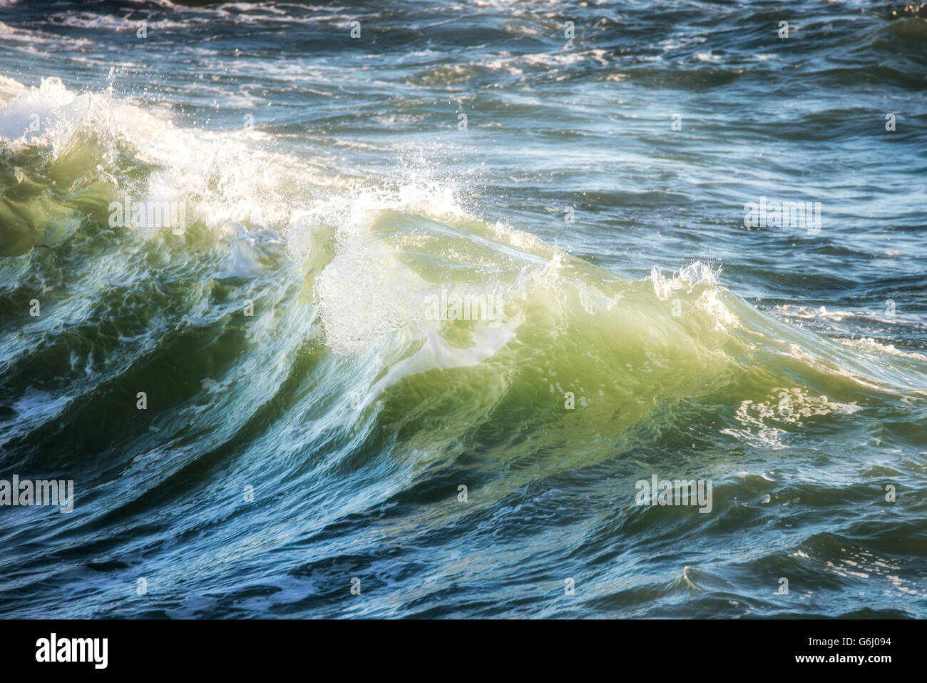 Hermosa cresta de ola del océano estrellarse al atardecer Foto de stock