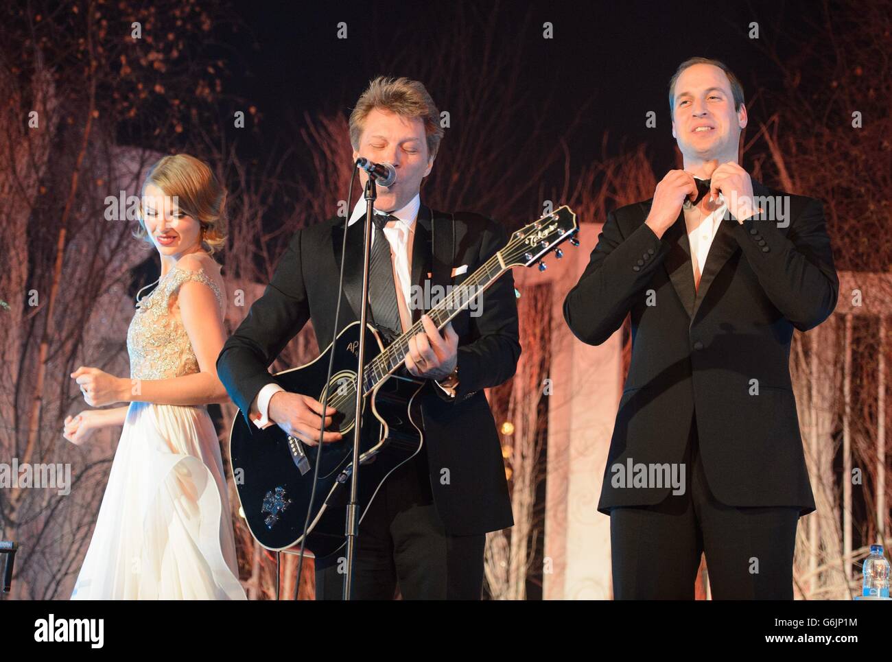 El duque de Cambridge (derecha) se endereza antes de cantar con Taylor Swift (izquierda) y Jon Bon Jovi en la cena de gala Centerpoint en el Palacio de Kensington, Londres. Foto de stock