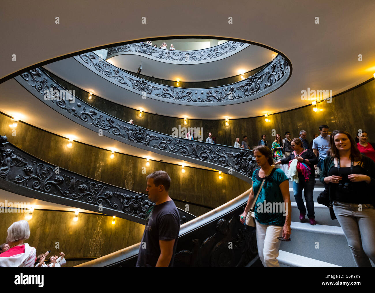 Los visitantes descienden de la famosa escalera de caracol en el Museo Vaticano en Roma, Italia Foto de stock