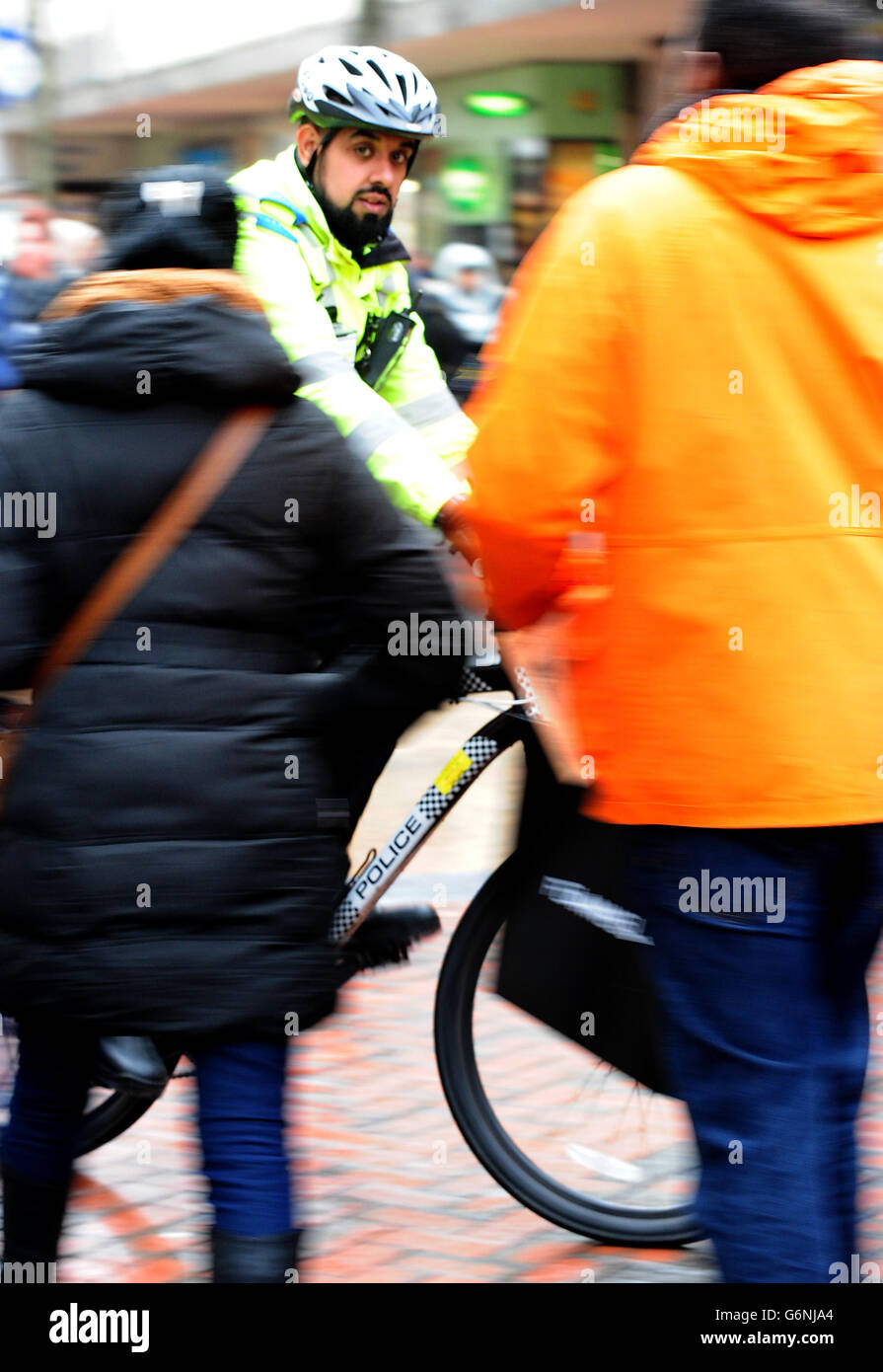 Un oficial de apoyo comunitario de la policía utiliza una bicicleta policial para patrullar las calles del centro de Birmingham. Foto de stock
