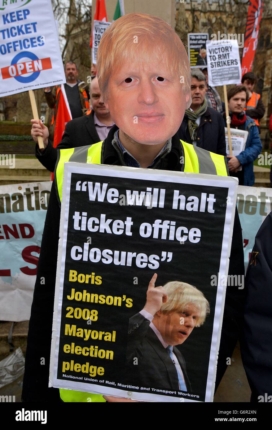 Una persona lleva una máscara de Boris Johnson ante una protesta de la Unión de Ferrocarriles Marítimos y Transportes (RMT) frente a las Casas del Parlamento en Westminster, Londres, contra el cierre de las oficinas de billetes de metro en Londres. Foto de stock