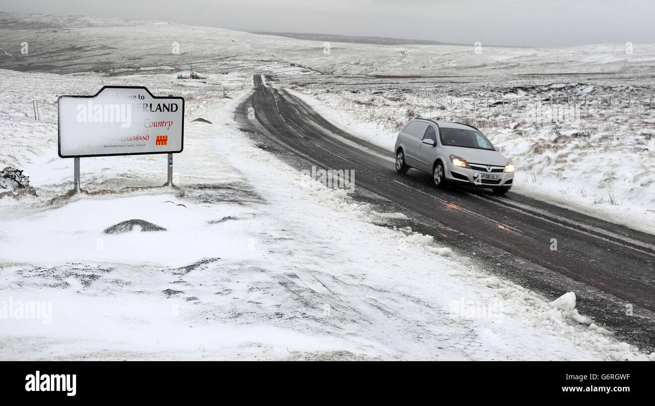 La nieve enmascara el signo que Marca la frontera Northumberland. Foto de stock