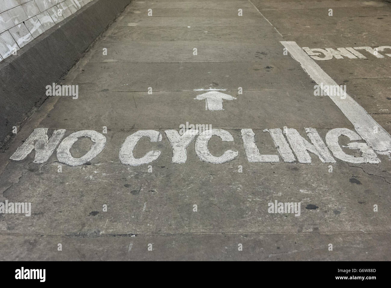 No hay signo de ciclismo escrito el piso del túnel de Greenwich, en Londres, Reino Unido Foto de stock