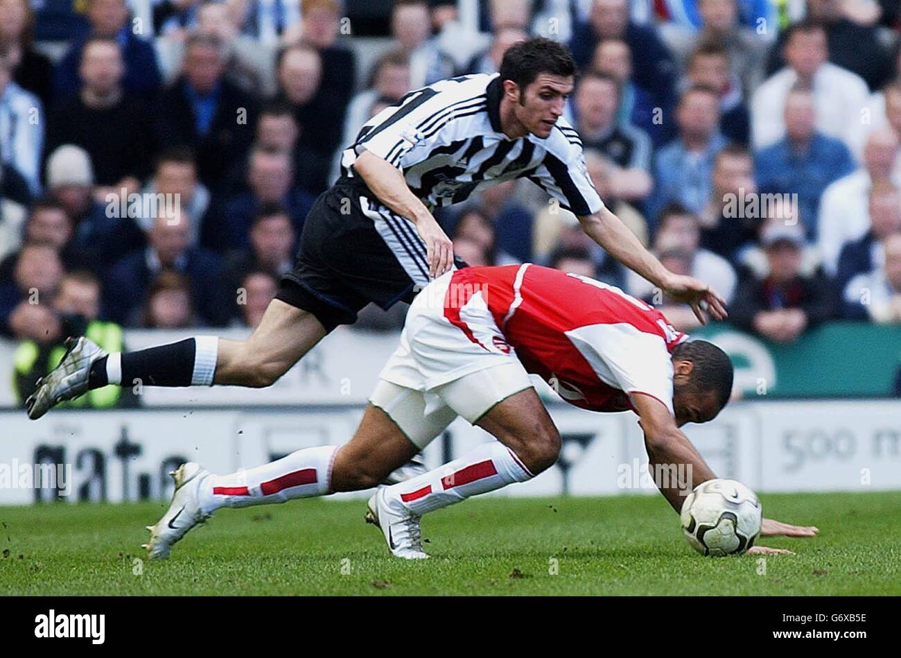 Thierry Henry del Arsenal se enamora del desafío de Andy o'Brien de Newcastle United durante el partido de la Premiership Barclaycard en el St James' Park de Newcastle. Foto de stock