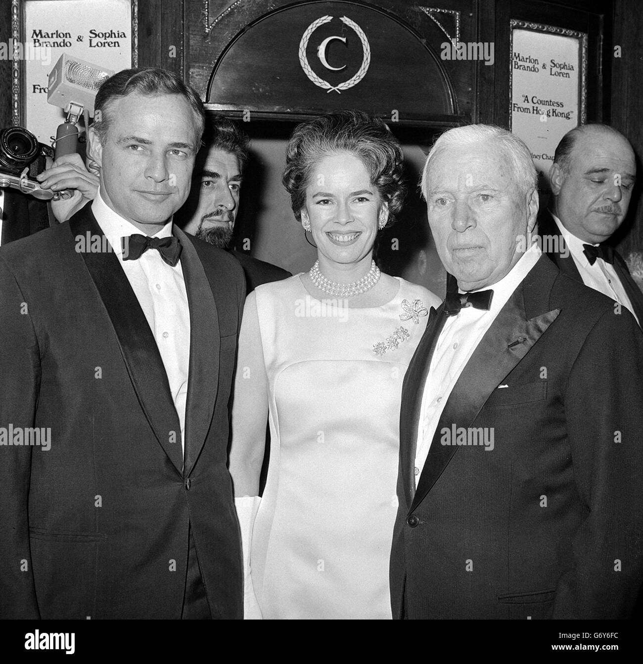 Charles Chaplin junto a su esposa Oona con Marlon Brando en el Teatro Carlton, Haymarket, Londres para el estreno mundial de caridad de la primera película de Chaplin durante diez años 'UNA condesa de Hong Kong'. Brando protagoniza la película con Sophia Loren. Foto de stock