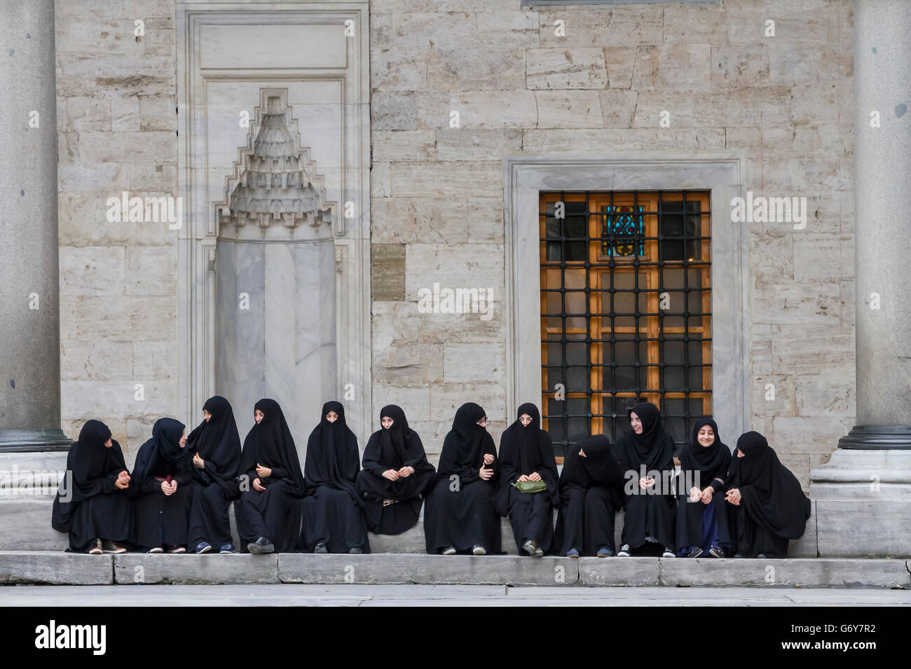 Grupo de mujeres sentadas y descansando en el patio de la Mezquita Azul en Estambul, Turquía. Foto de stock