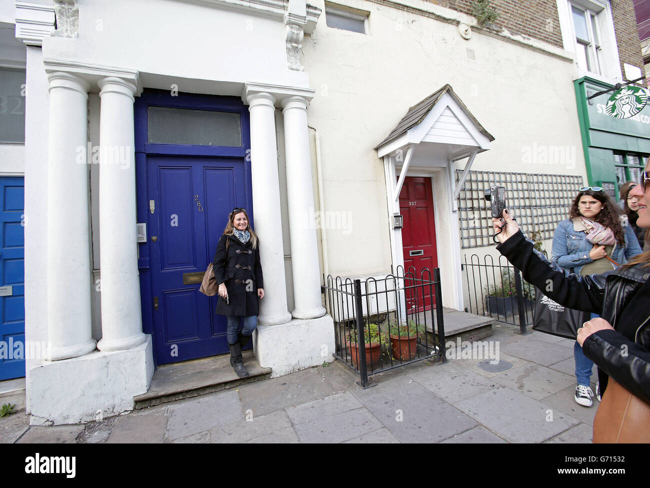 Los turistas que toman fotografías fuera de la puerta azul de 280  Westbourne Park Road, cuyo exterior aparece en la película de 1999 'Notting  Hill' como el lugar donde vivió el personaje