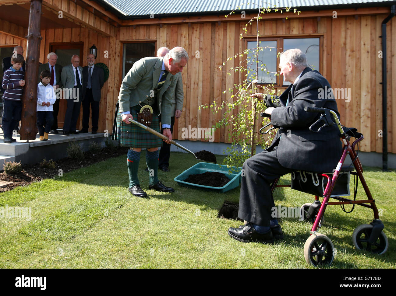 El Duque de Rothesay con Alexander Alexander mientras planta un árbol durante una visita al Parque de Caravana Ballater en Aberdeenshire. Foto de stock