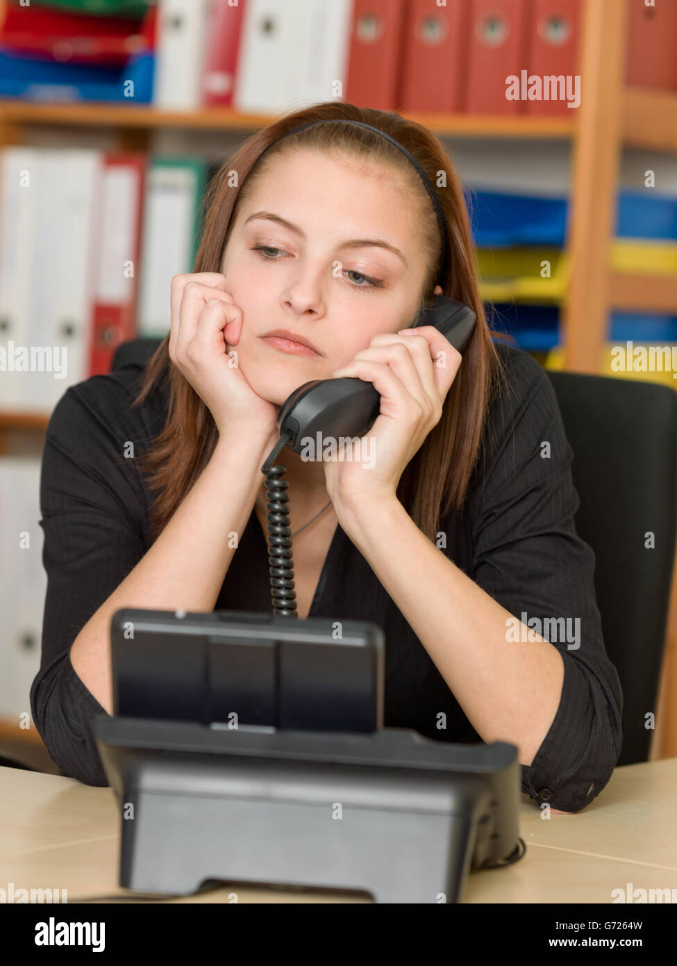 Hembra aburrido oficinista haciendo una llamada telefónica Foto de stock