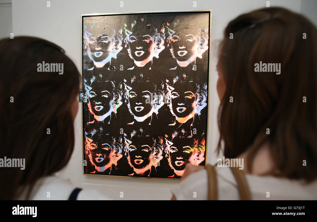 Los visitantes miran a 'Nine Multicolor Marilyns' (serie de reversión) por Andy Warhol (venta est &Pound;4-&Pound;6 millones de libras) en la exposición Summer at Sotheby's, Magnificent Works en Londres, que lanza su temporada de subastas de verano. Foto de stock