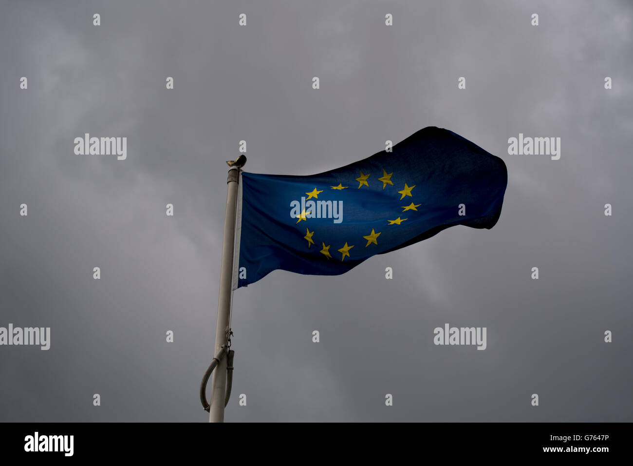 Unión Europea (UE) bandera ondeando al viento con nubarrones detrás. Gran Bretaña salió de la UE en un referendo reciente. Foto de stock