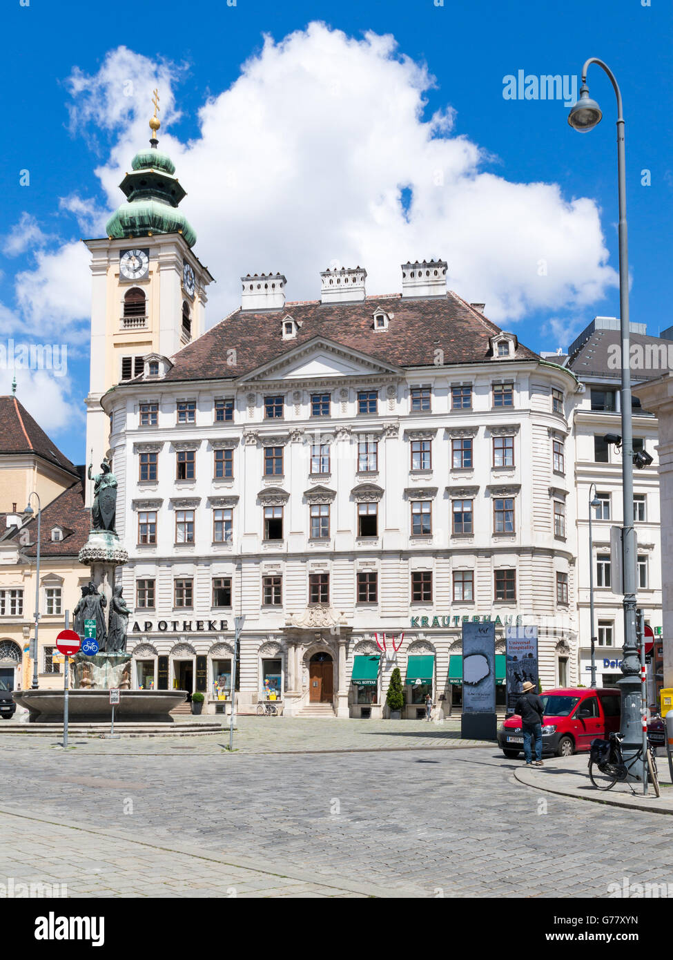 Escena de una calle de la plaza Freyung con torre de Scottish abadía y farmacia edificio en el centro antiguo de la ciudad de Viena, Austria Foto de stock
