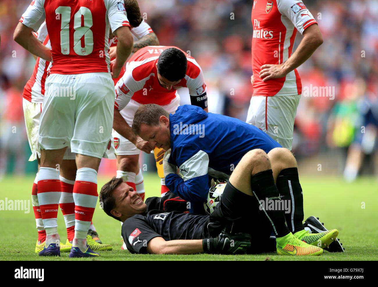 Fútbol - Escudo comunitario - Arsenal contra Manchester City - Estadio Wembley. El portero del Arsenal Wojciech Szczesny es tratado después de una lesión por el fiiso del Arsenal Colin Lewin Foto de stock