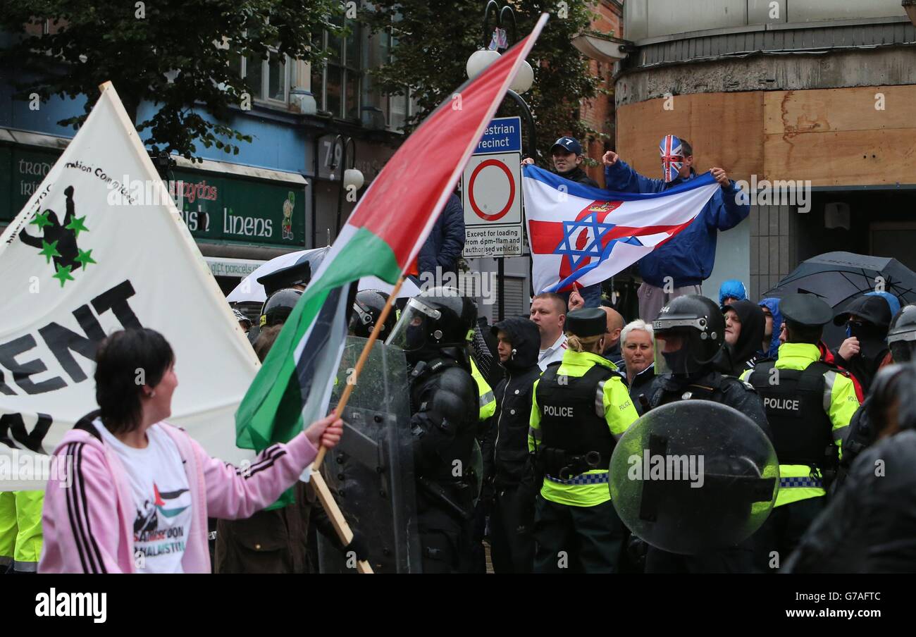 Se ven banderas de Palestina e Israel, ya que la policía separa a los manifestantes de banderas leales de un desfile republicano en el centro de la ciudad de Belfast, que ha pasado en gran medida pacíficamente. Foto de stock