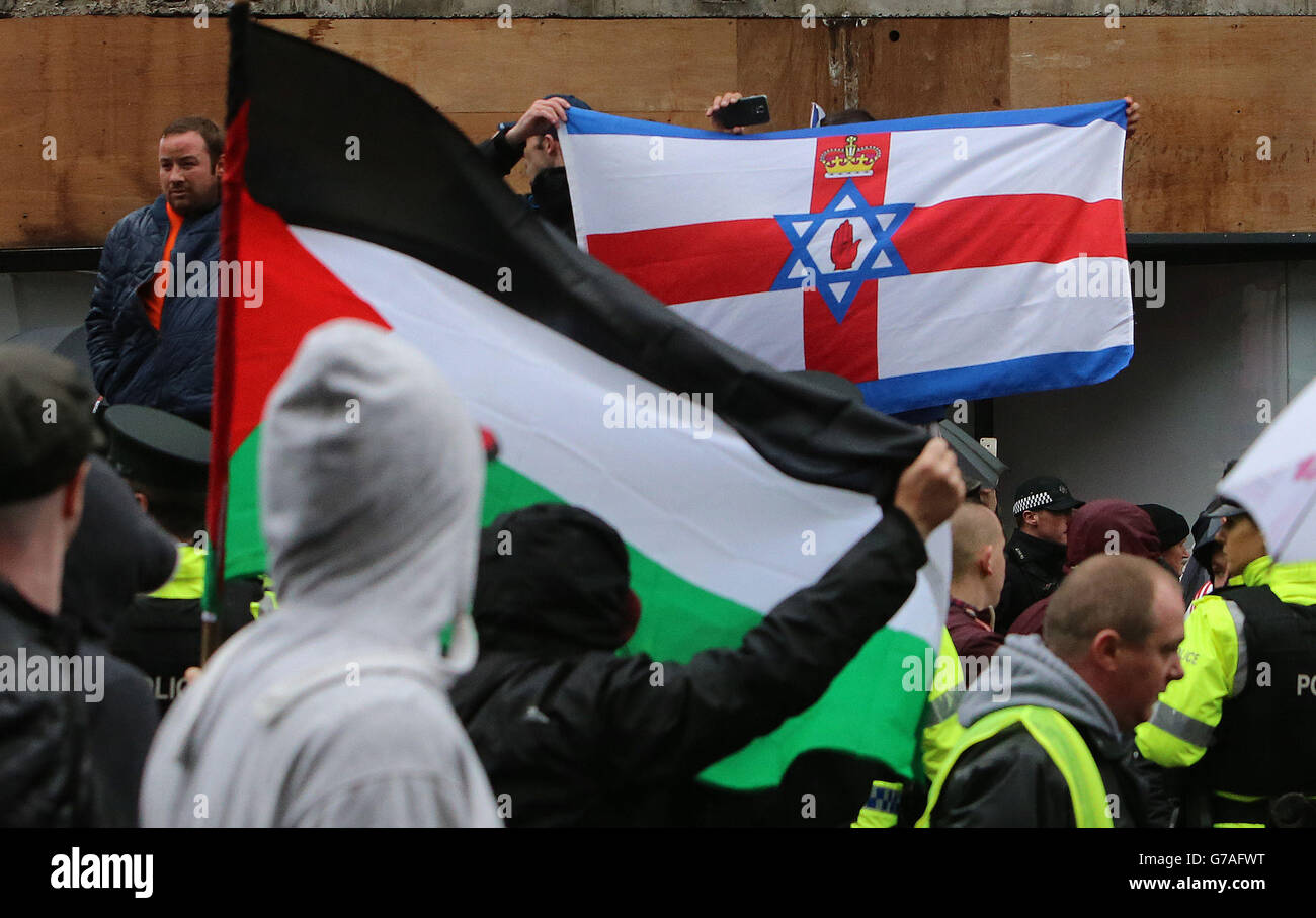 Se ven banderas de Palestina e Israel, ya que la policía ha separado a los manifestantes de banderas leales de un desfile republicano en el centro de Belfast, que ha pasado en gran medida pacíficamente. Foto de stock