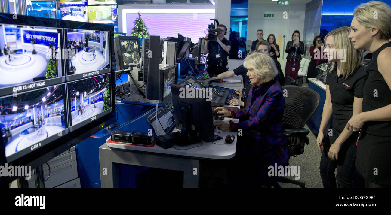 La duquesa de Cornwall mira un monitor que controla remotamente cámaras de televisión en el estudio de noticias Sky Sports en Londres, con Rachel Applin, y Melissa Bartlett durante una visita a Sky con el Príncipe de Gales. Foto de stock