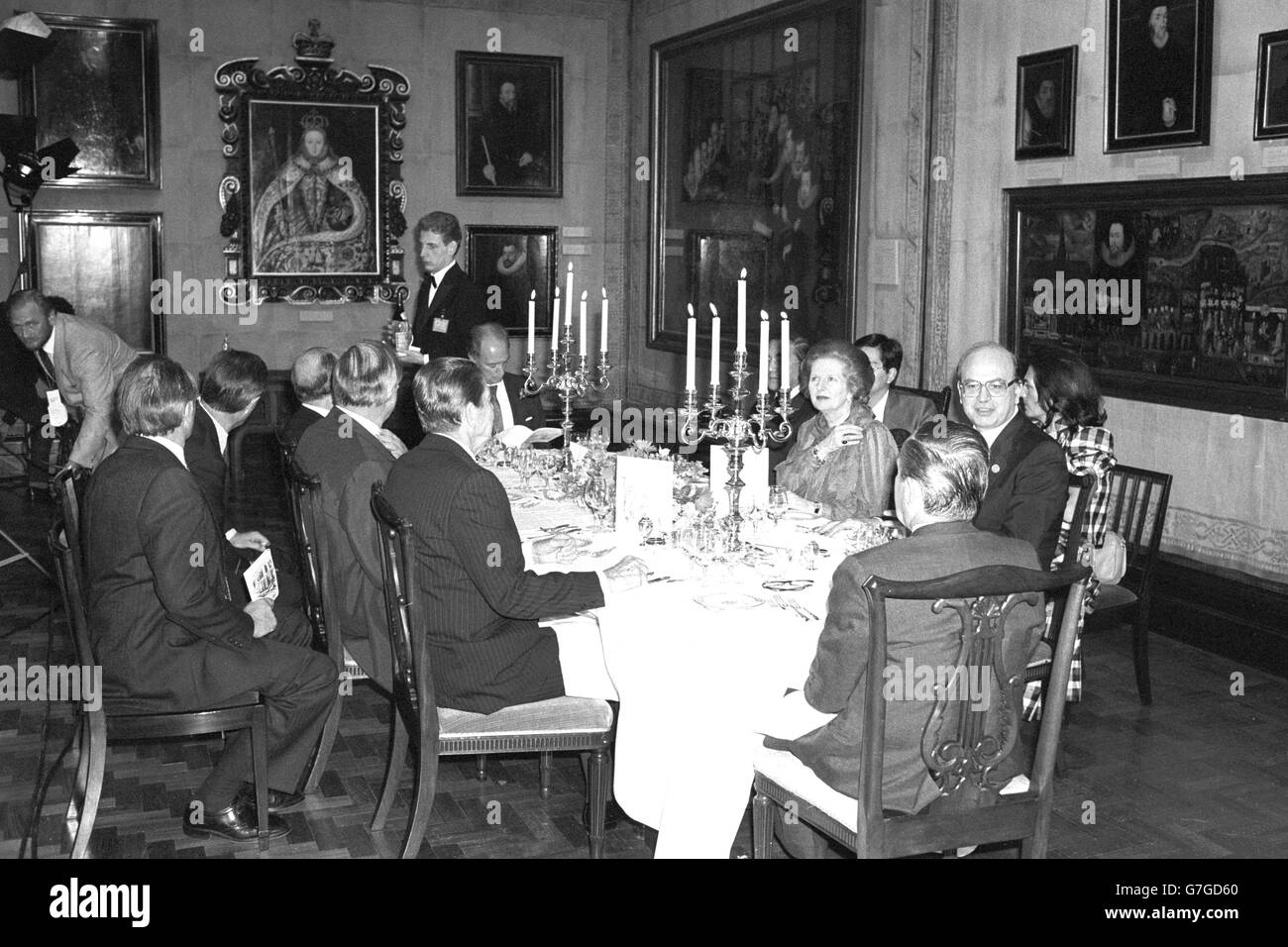 La primera ministra Margaret Thatcher organiza una cena para los jefes de las delegaciones en la Cumbre Económica de Londres, en la sala Tudor de la Galería Nacional de Retratos. En el sentido de las agujas del reloj desde Thatcher: El primer ministro italiano Benito Craxi, el Comisionado de la CEE Gaston Thorn, el presidente estadounidense Ronald Reagan, el canciller alemán occidental Helmut Kohl, el presidente francés Francois Mitterand, el primer ministro canadiense Pierre Trudeau y el primer ministro japonés Yasuhiro Nakasone. Foto de stock