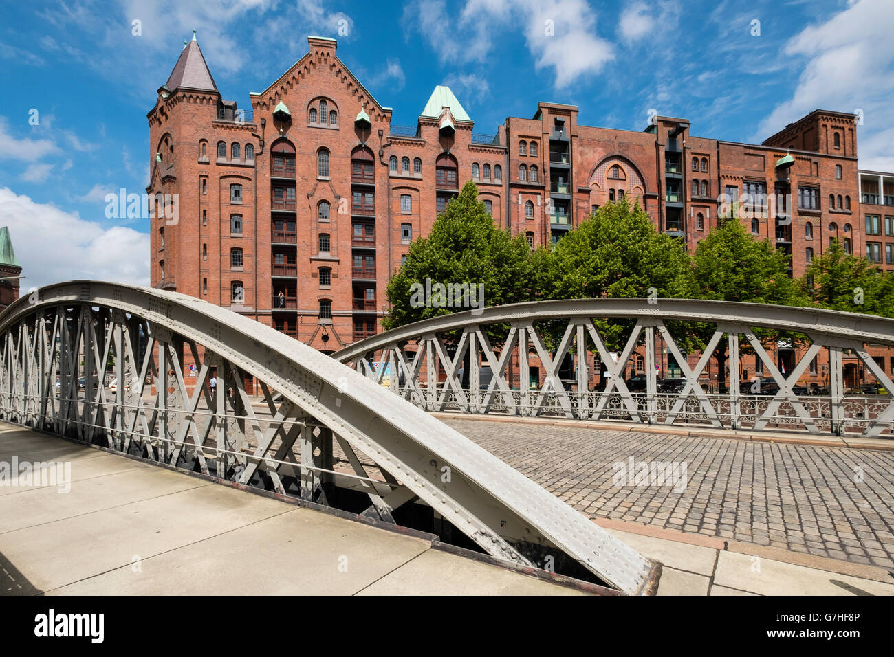 Ver histórico de almacenes de ladrillos rojos y el puente del Speicherstadt junto a canales en Hamburgo, Alemania Foto de stock