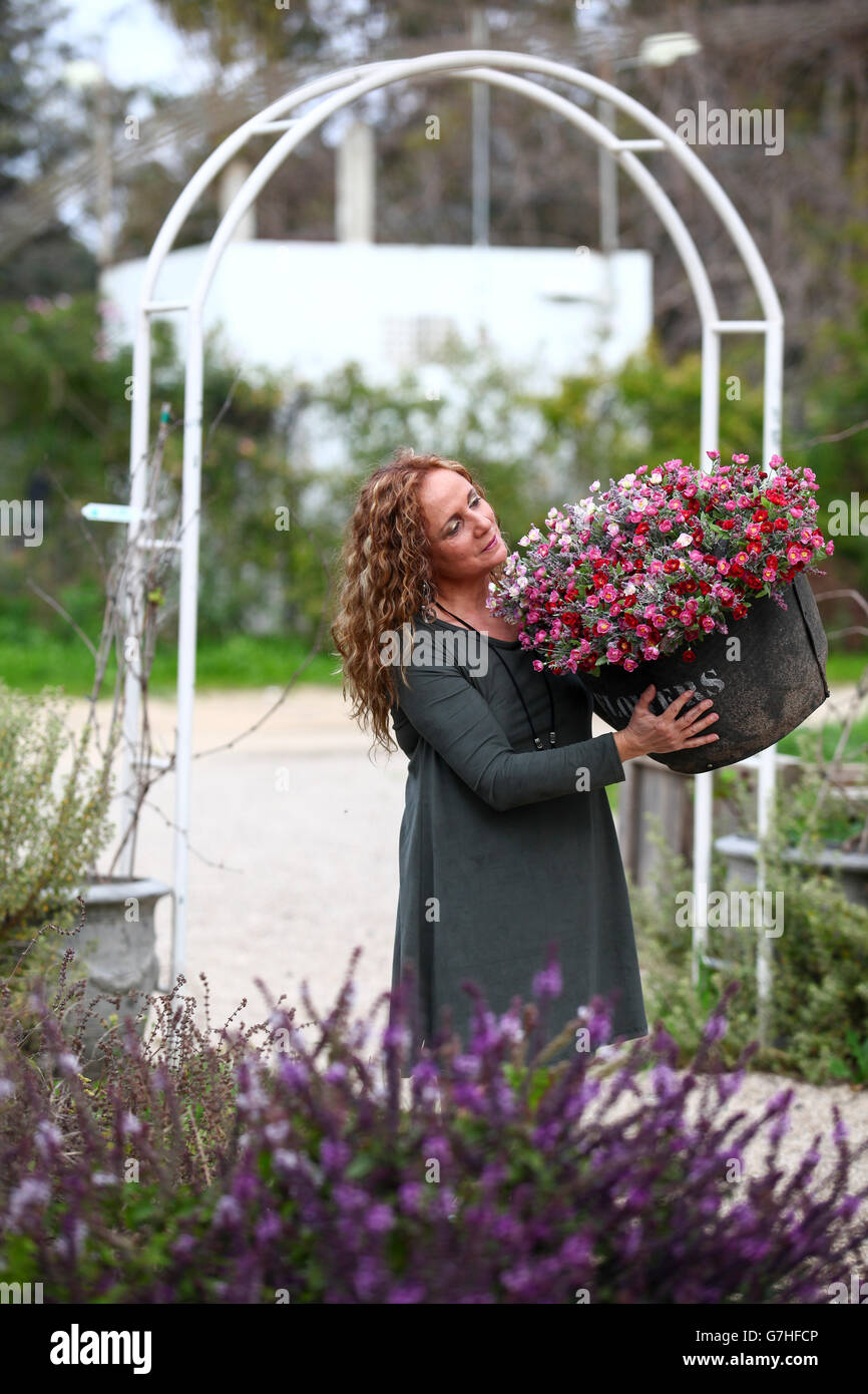 Mujer admira las flores en su jardín Foto de stock