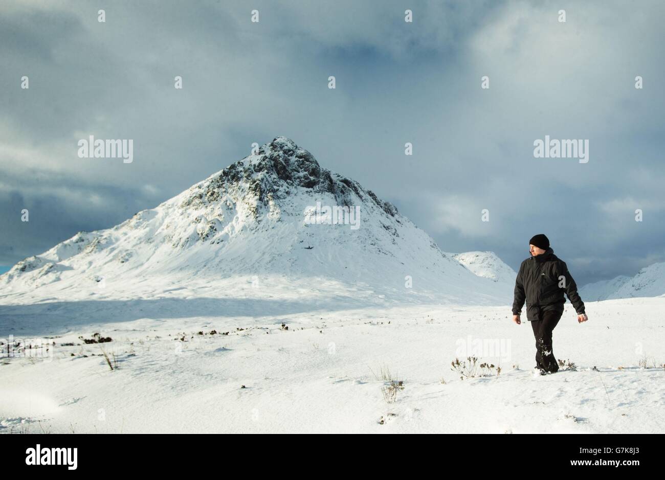 Un hombre hace su camino a través de la nieve profunda cerca de Buachaille Etive Mountain en Glencoe, Escocia, mientras los pronosticadores están prediciendo la noche más fría en Gran Bretaña hasta ahora este invierno. Foto de stock