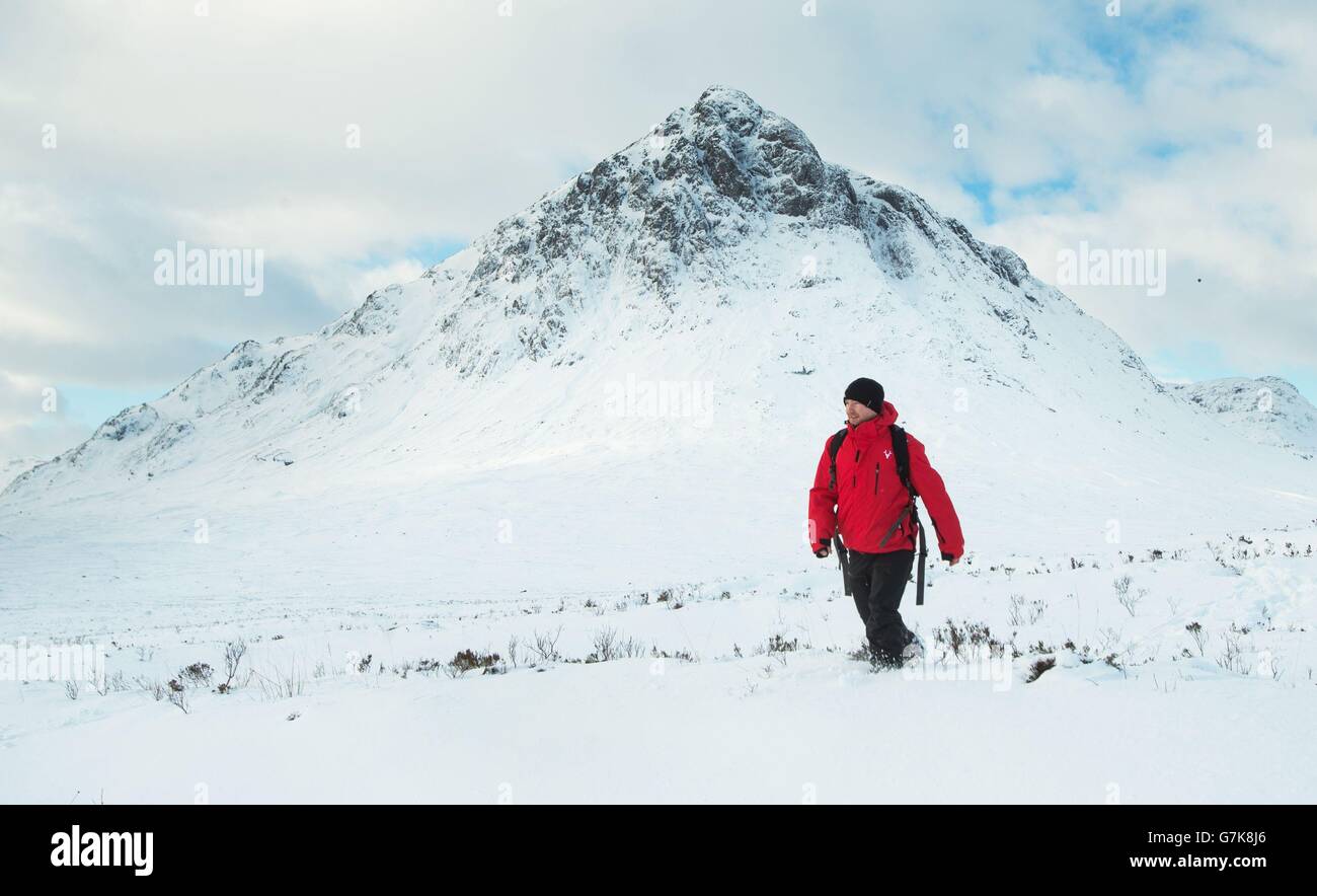 Un hombre hace su camino a través de la nieve profunda cerca de Buachaille Etive Mountain en Glencoe, Escocia, mientras los pronosticadores están prediciendo la noche más fría en Gran Bretaña hasta ahora este invierno. Foto de stock