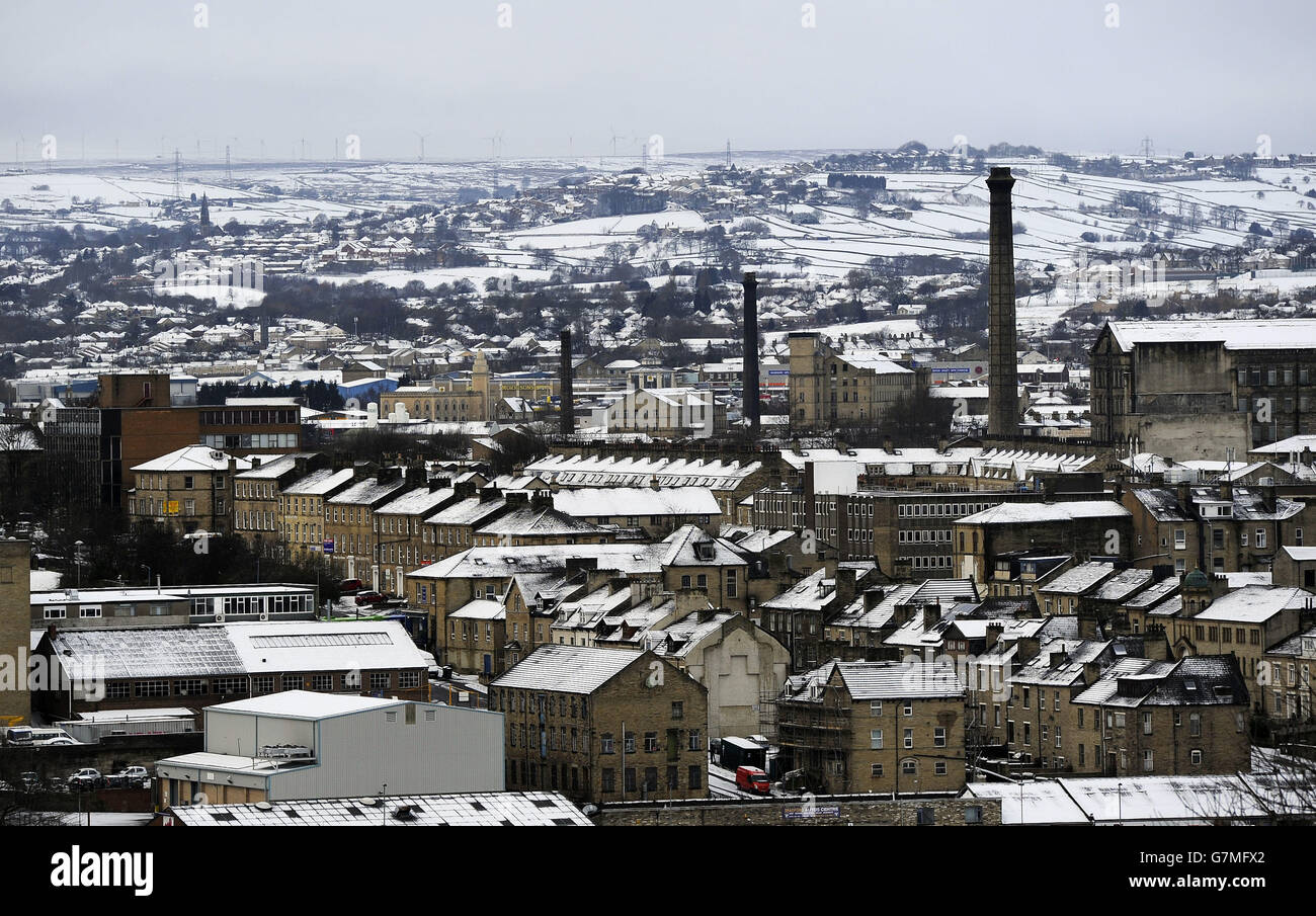 Una vista general de las antiguas chimeneas del molino de Bradford, con las calles adosadas circundantes y las colinas por encima de la ciudad cubiertas de nieve, después de fuertes lluvias de nieve. Foto de stock