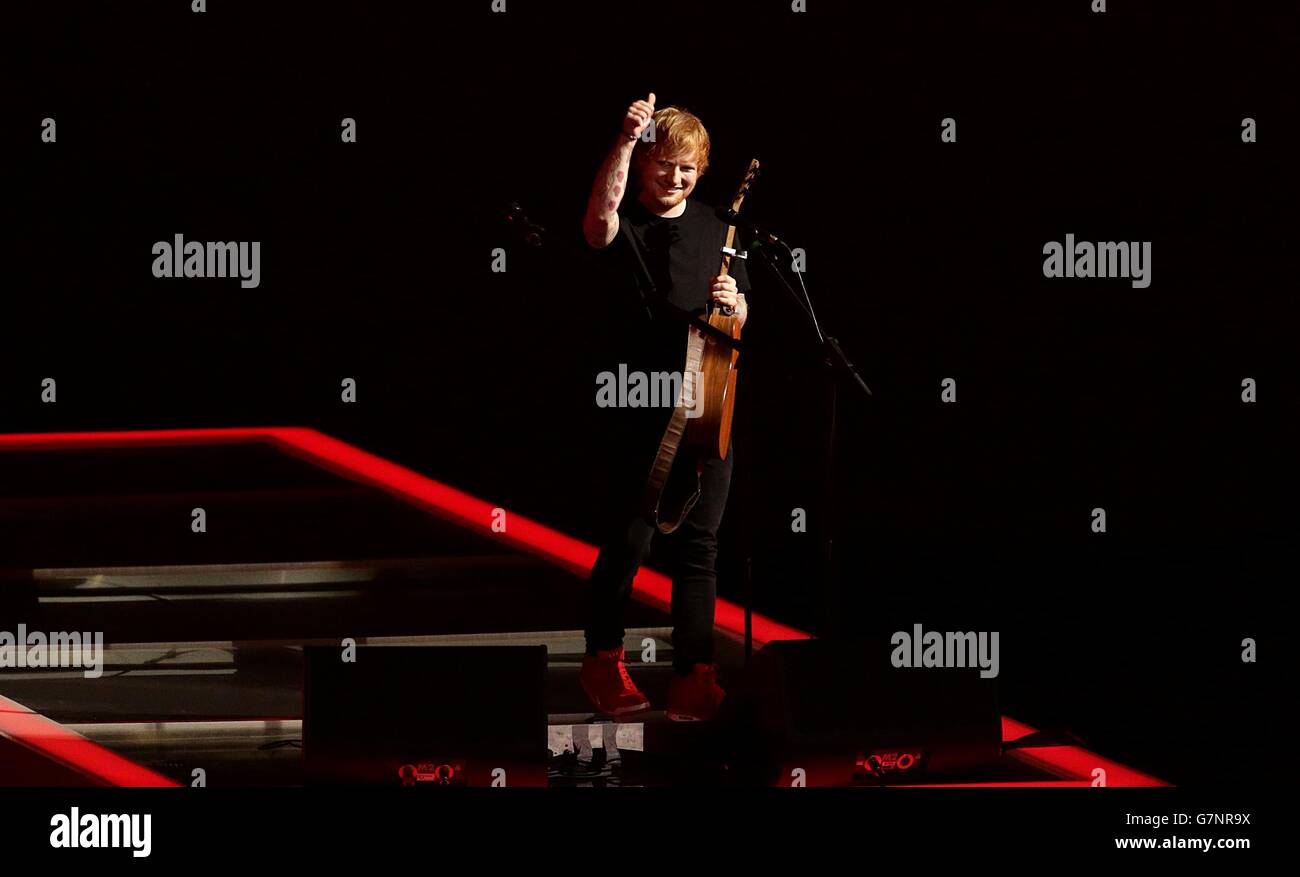 Ed Sheeran da el visto bueno después de su actuación en el escenario durante los Premios Brit 2015 en el O2 Arena, Londres. Foto de stock