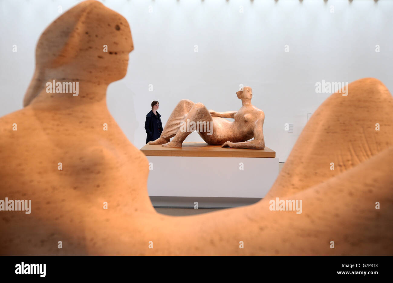 Reproducida con permiso de la Fundación Henry Moore Kate Robertson analiza los 'ángulos de la figura de revestimiento' y 'Figura de revestimiento violada' de Henry Moore (primer plano), que forman parte de la exposición de regreso a la Tierra en el Parque de esculturas de Yorkshire. Foto de stock