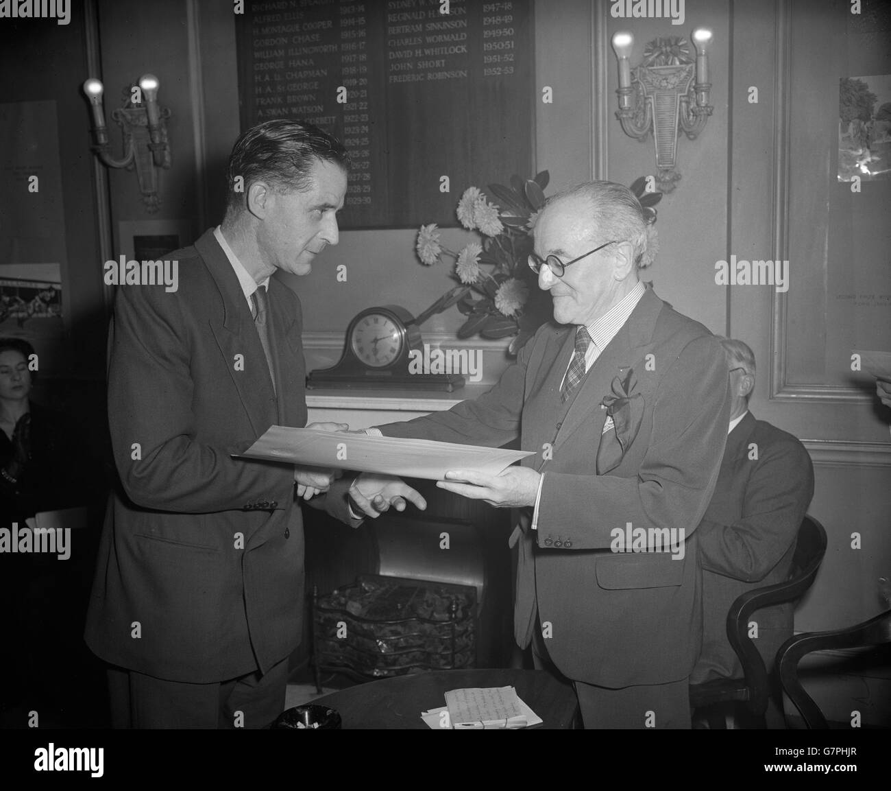 Sir Gerald Kelly (r), Presidente de la Royal Academy, presentando un cheque de 50 guineas junto con un diploma iluminado y una copia del Britannica Book of the Year 1954 a PA-Reuter Photos Photographer, Edward Brooks, en el Instituto de Fotógrafos británicos, Gordon Square, Londres. Brooks ganó el premio como primer premio en la categoría de largometraje en la Sexta competencia Anual, British Press Pictures of the Year, patrocinado por la Enciclopedia Britannica. La imagen que le ganó el premio fue de la buena Quad deseando "feliz cumpleaños" a su abuela de 100 años. Foto de stock