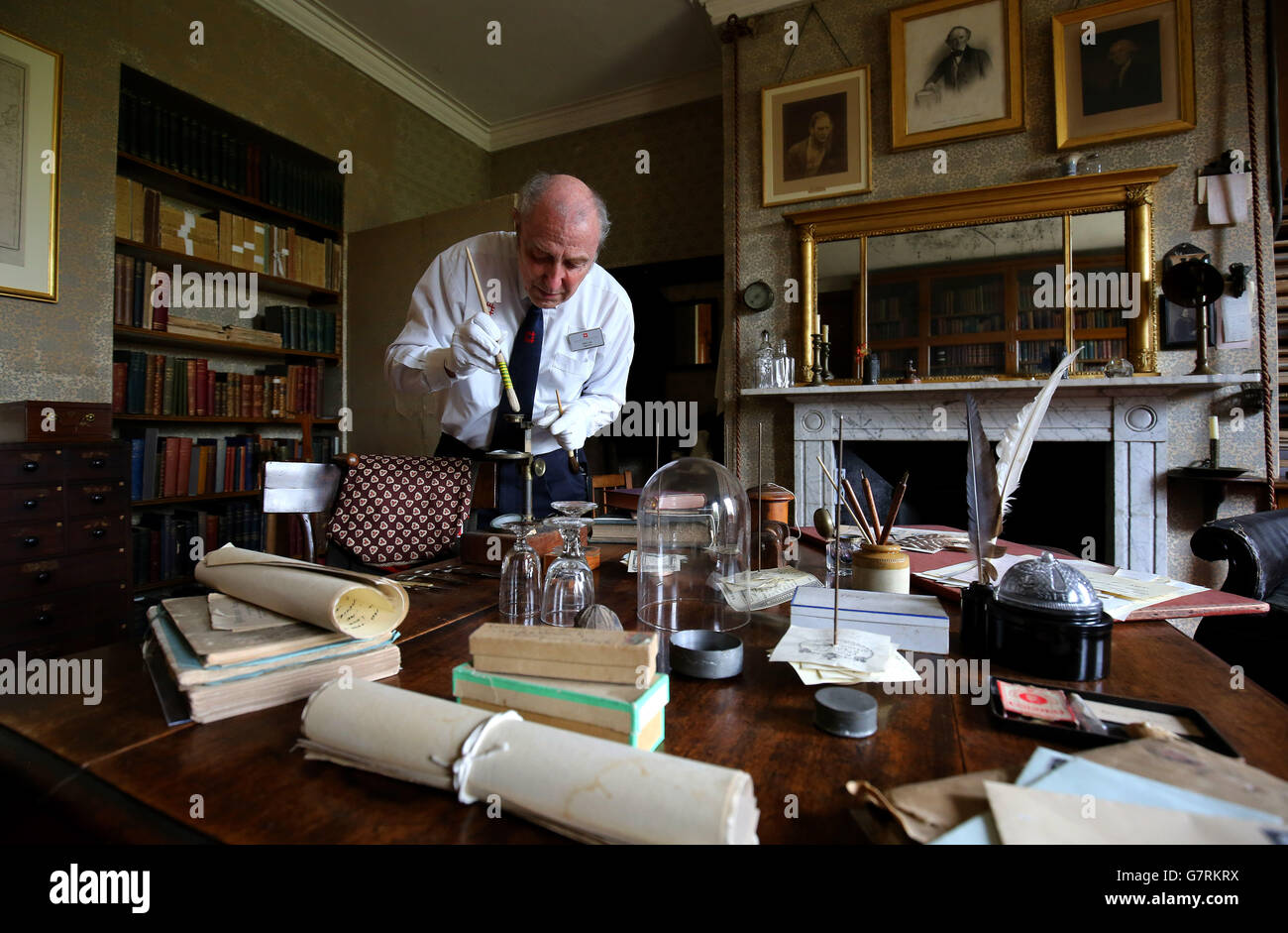 Phil Cole, del Patrimonio Inglés, limpia delicadamente los objetos y  artefactos en el estudio del científico Charles Darwin en Down House en  Kent, su casa durante 40 años hasta su muerte en
